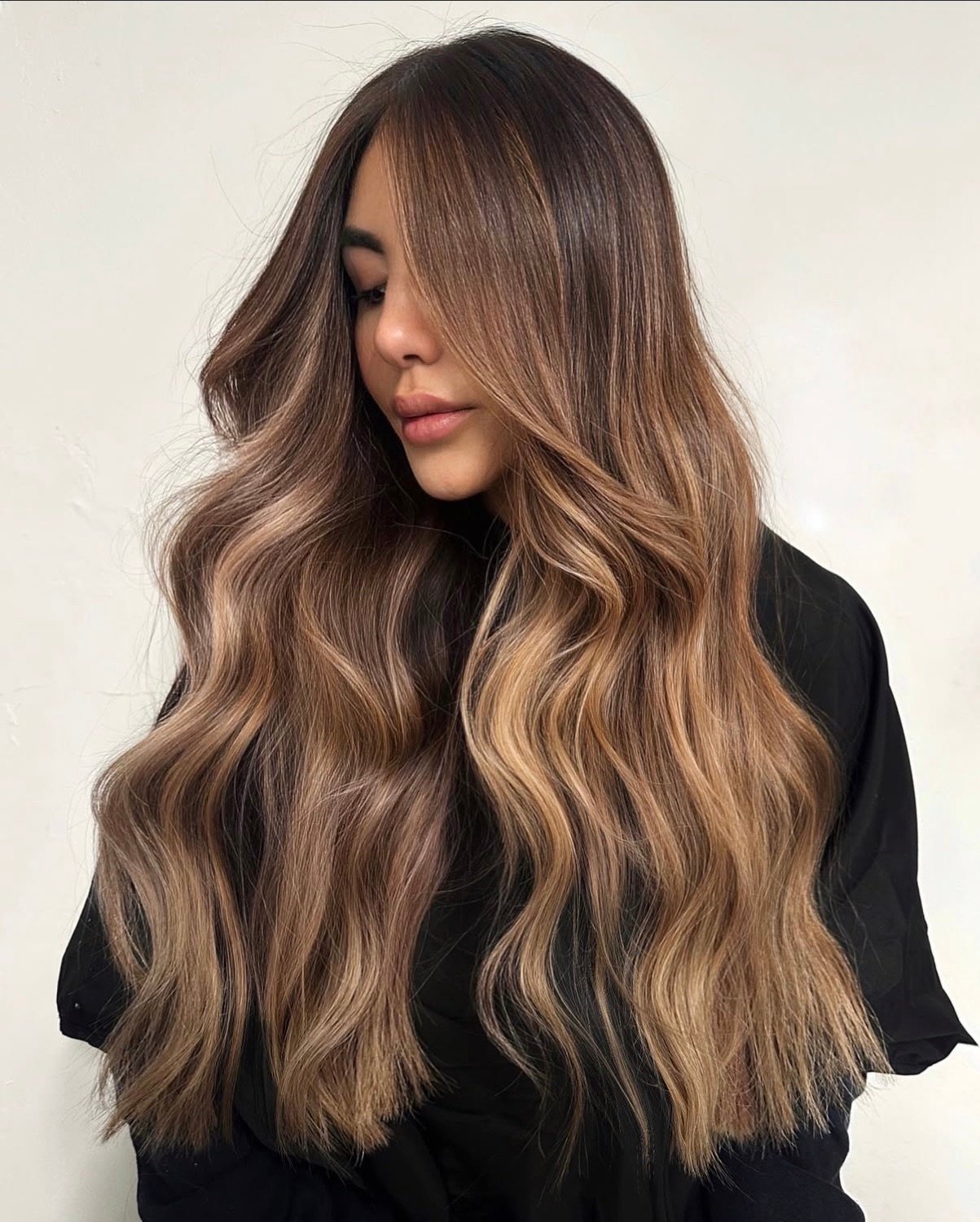 Long caramel brunette balayage in soft, glossy waves